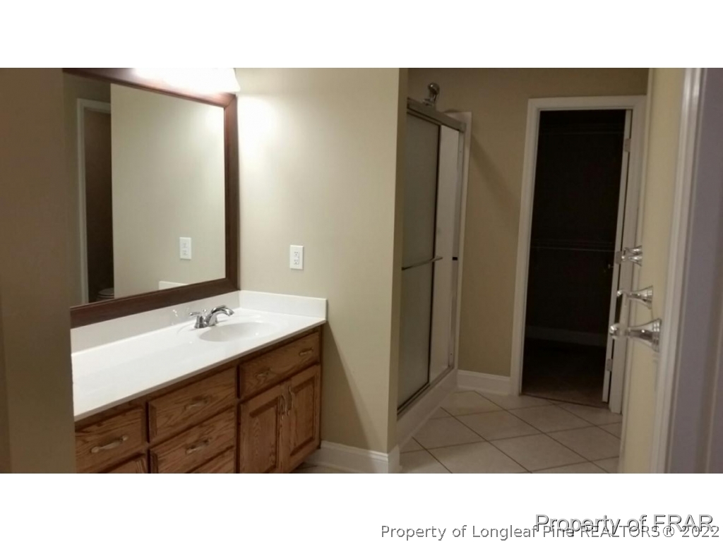 5265 Stewart Road Wade, NC 28395 - Photo 12 of 26 a bathroom with a sink a mirror and a shower