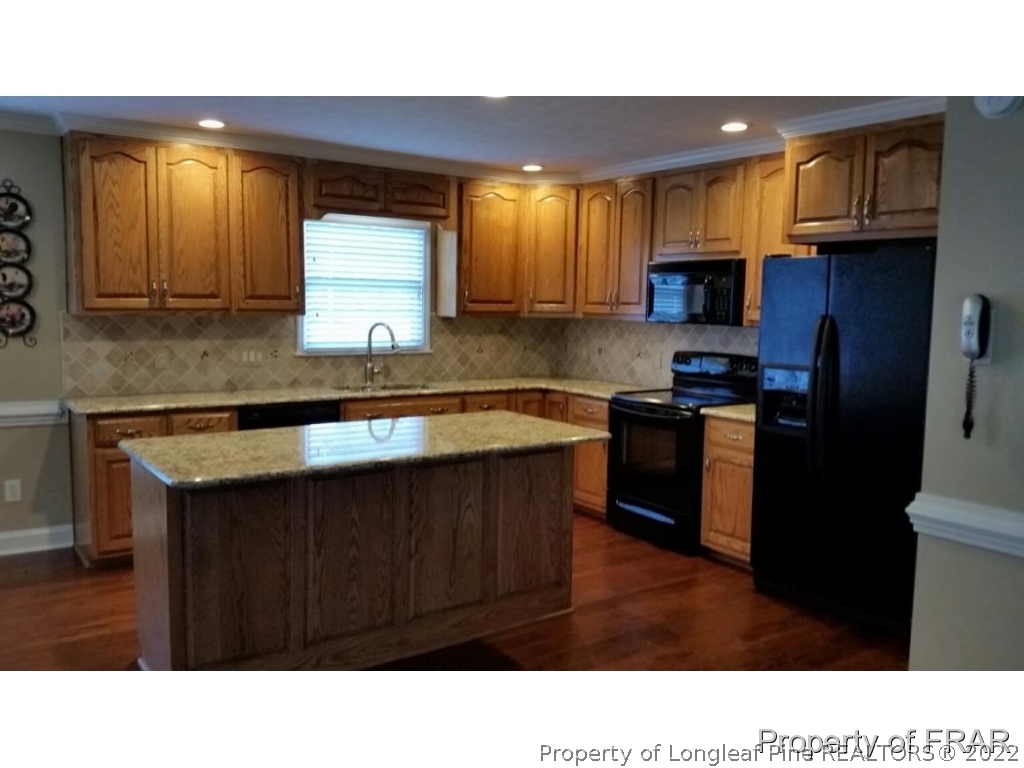 5265 Stewart Road Wade, NC 28395 - Photo 7 of 26 a kitchen with stainless steel appliances a sink a stove a refrigerator cabinets and a window