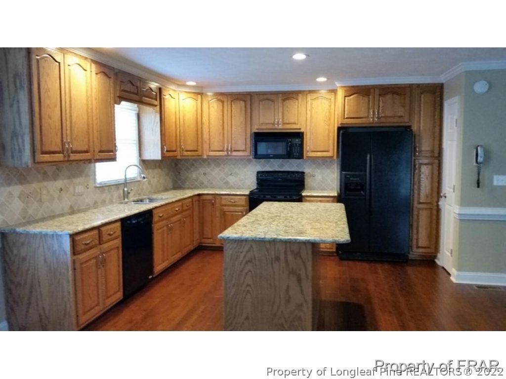 5265 Stewart Road Wade, NC 28395 - Photo 8 of 26 a kitchen with a sink a stove and cabinets