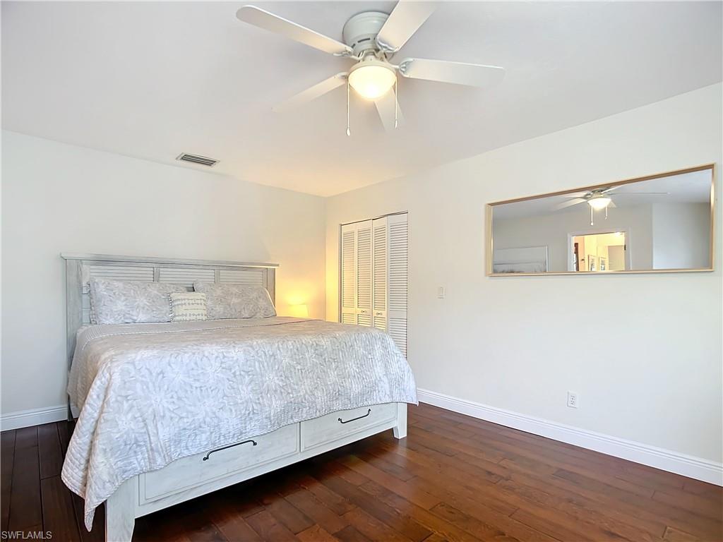 2860 Citrus Lake Drive, Unit R202 Naples, FL 34109 - Photo 31 of 50 a bedroom with a bed and a chandelier