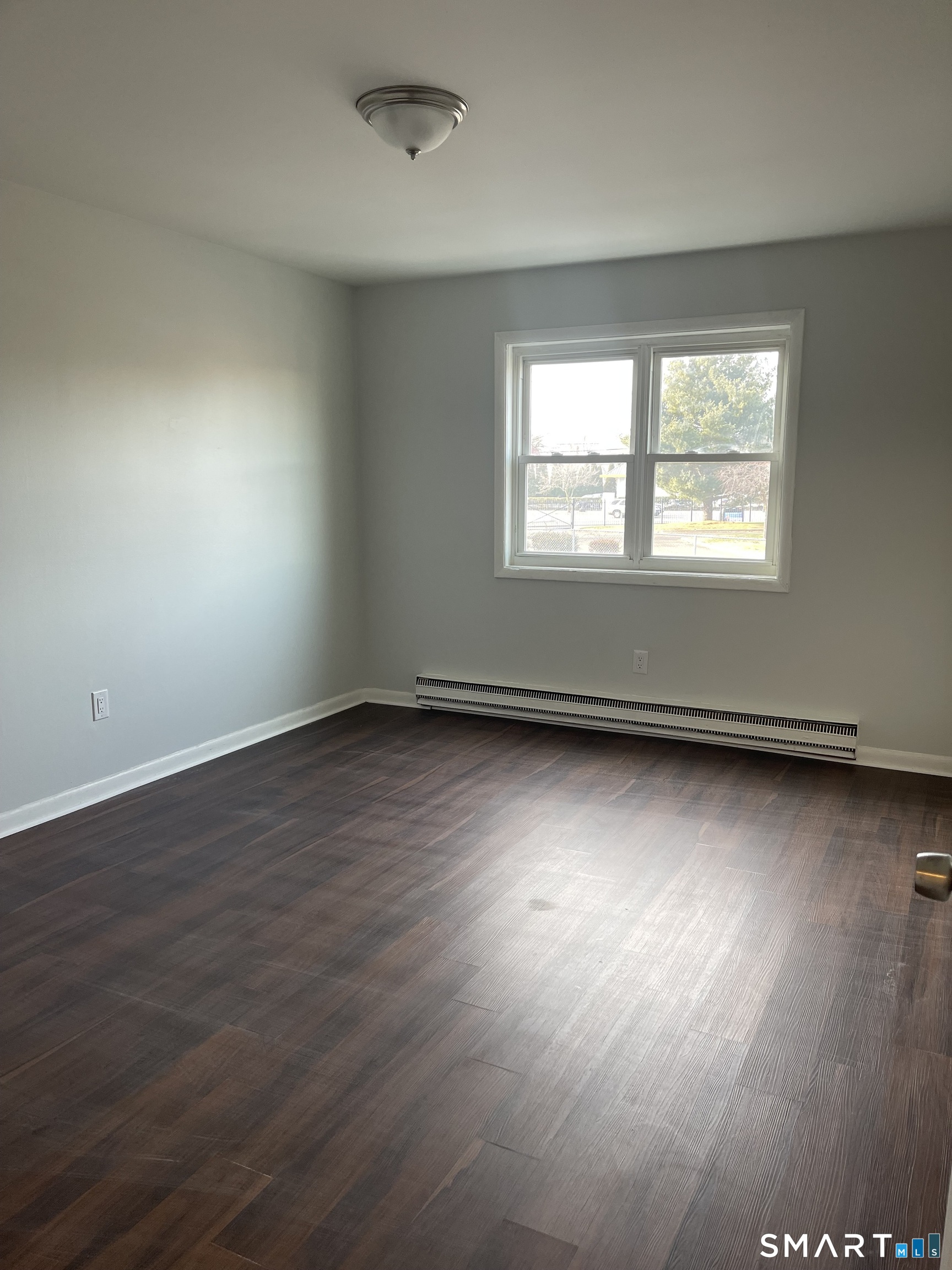 45 Monroe Street, Unit B2 Bridgeport, CT 06605 - Photo 12 of 12 an empty room with wooden floor and windows
