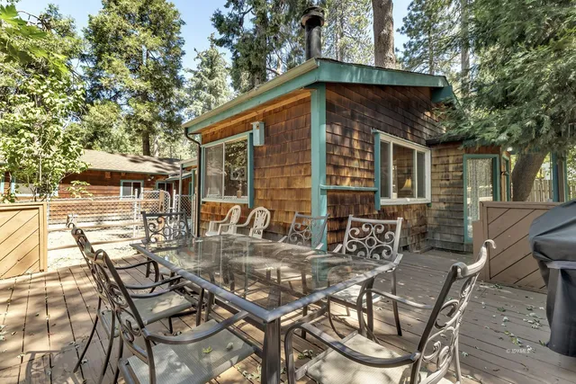 a view of a patio with table and chairs with wooden floor and fence