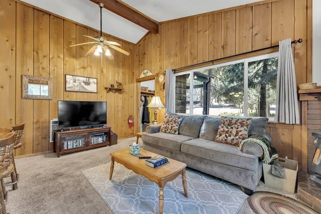 a living room with furniture a flat screen tv and a window
