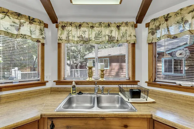 a dining room with stainless steel appliances kitchen island granite countertop a table chairs and a refrigerator