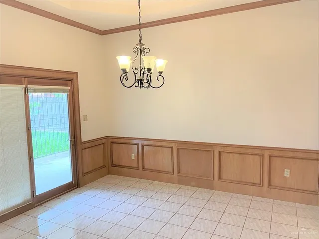 a view of an empty room and chandelier fan