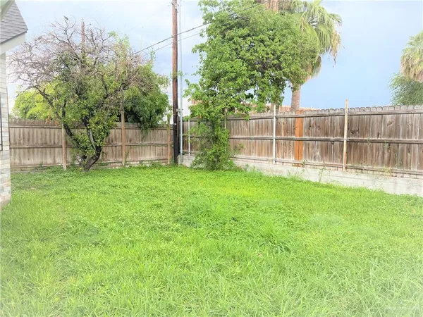 a view of a backyard with a small cabin and wooden fence