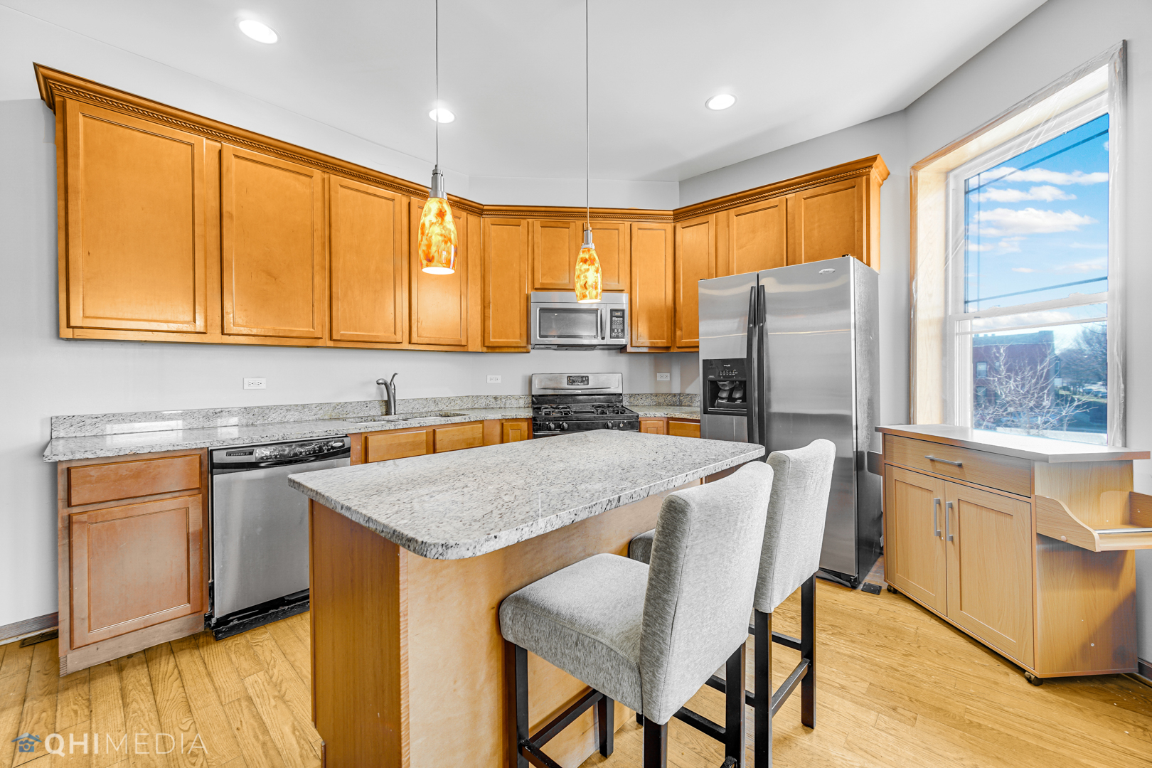 4341 South Prairie Avenue, Unit 2 Chicago, IL 60653 - Photo 2 of 11 a kitchen with stainless steel appliances granite countertop a refrigerator a stove top oven a sink and cabinets