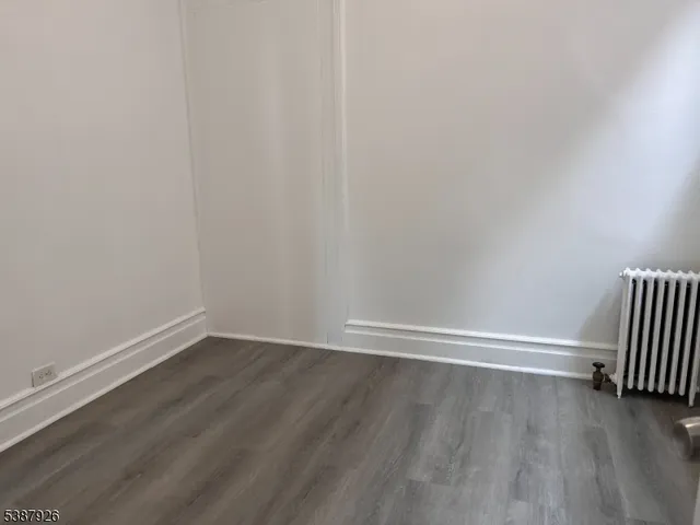 a view of an empty room and wooden floor