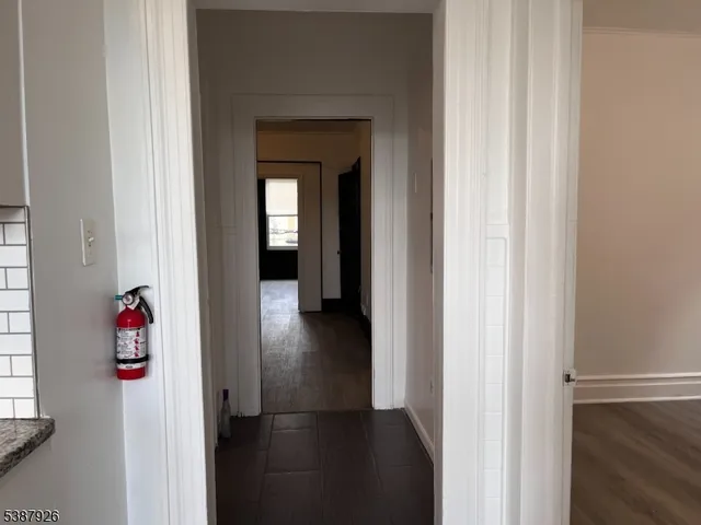 a view of a hallway with wooden floor and closet