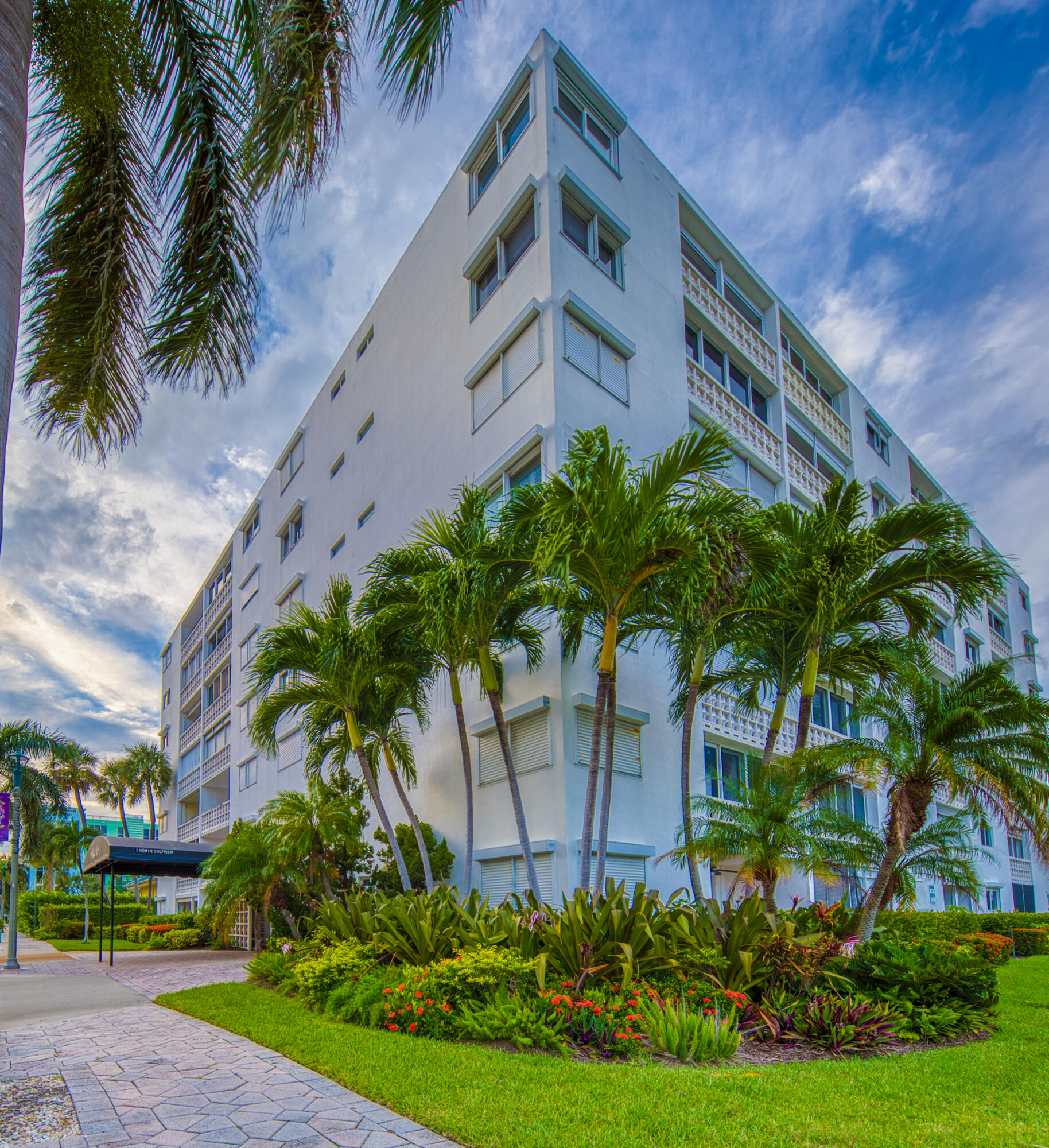 1 North Golfview Road, Unit 601 Lake Worth Beach, FL 33460 - Photo 19 of 51 a front view of a house with a yard and potted plants