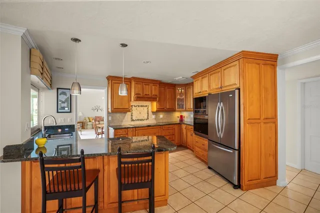 a kitchen with stainless steel appliances granite countertop a refrigerator and a stove top oven