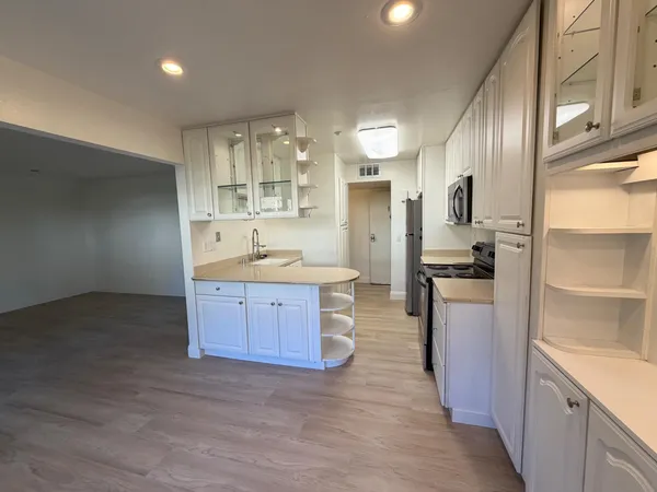 a kitchen with stainless steel appliances kitchen island granite countertop a refrigerator and a sink