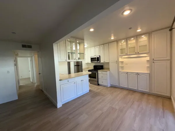 a kitchen with stainless steel appliances granite countertop a refrigerator and a stove top oven