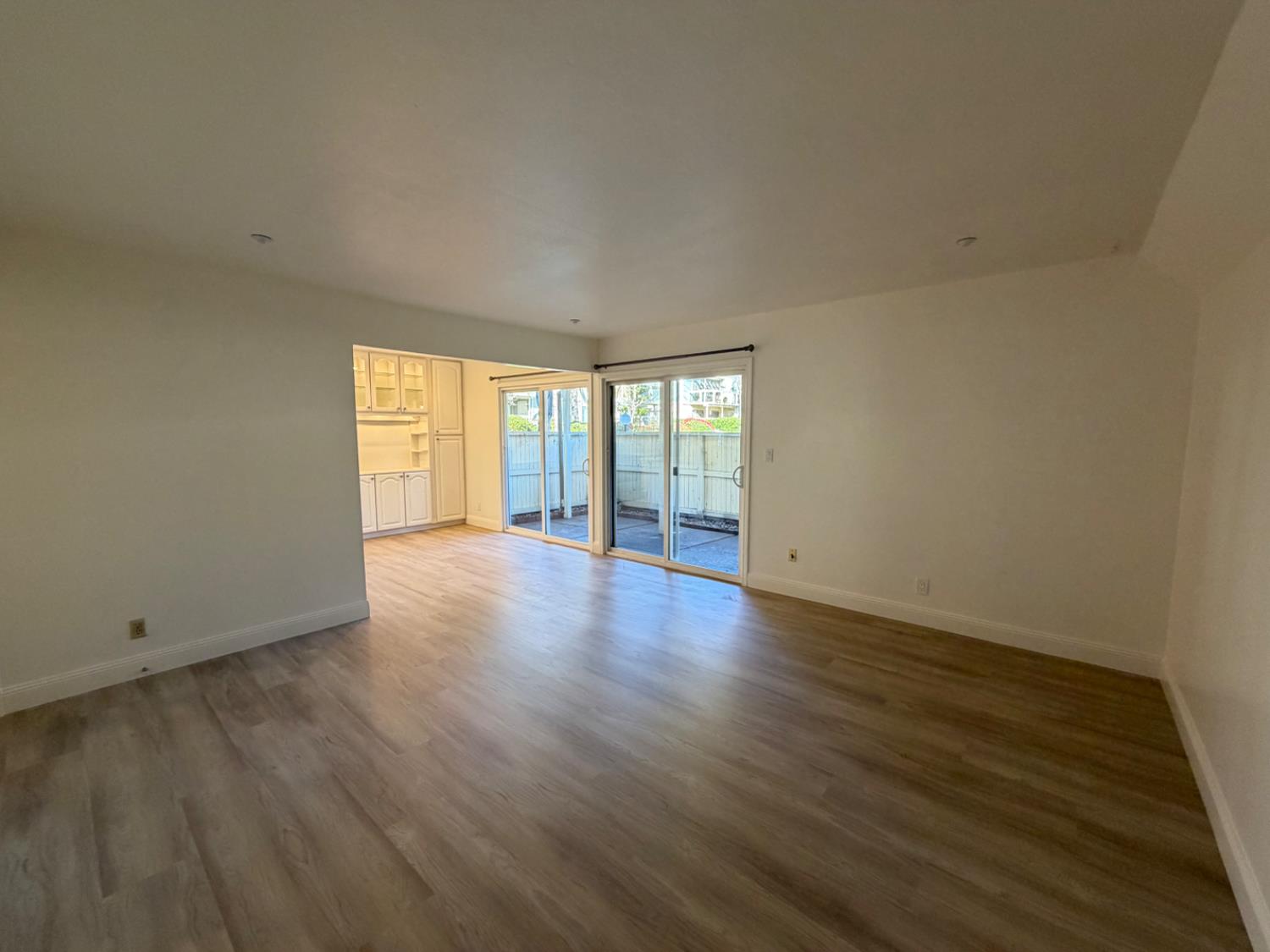 6241 Riverside Boulevard, Unit 112 Sacramento, CA 95831 - Photo 8 of 33 a view of an empty room with wooden floor and a window