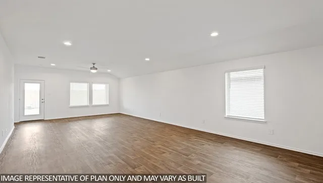 an empty room with wooden floor and window