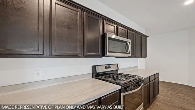 a kitchen with stainless steel appliances granite countertop a stove a microwave and a sink