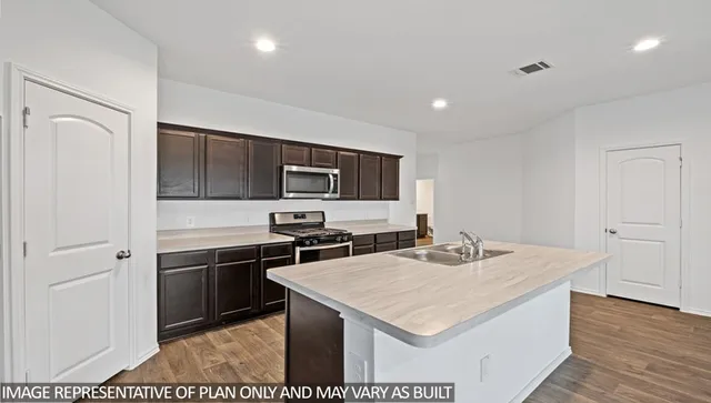 a kitchen with a stove a sink and a refrigerator