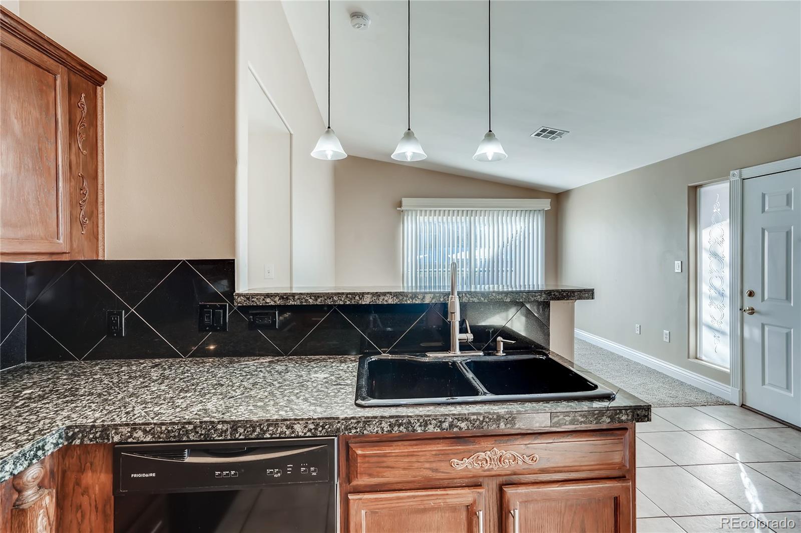 8459 South Little Rock Way, Unit 201 Highlands Ranch, CO 80126 - Photo 11 of 28 a kitchen with stainless steel appliances granite countertop a sink a stove and a microwave