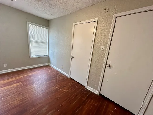 an empty room with wooden floor and white walls