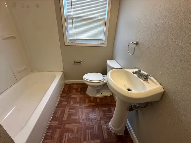 a white toilet sitting next to a white sink