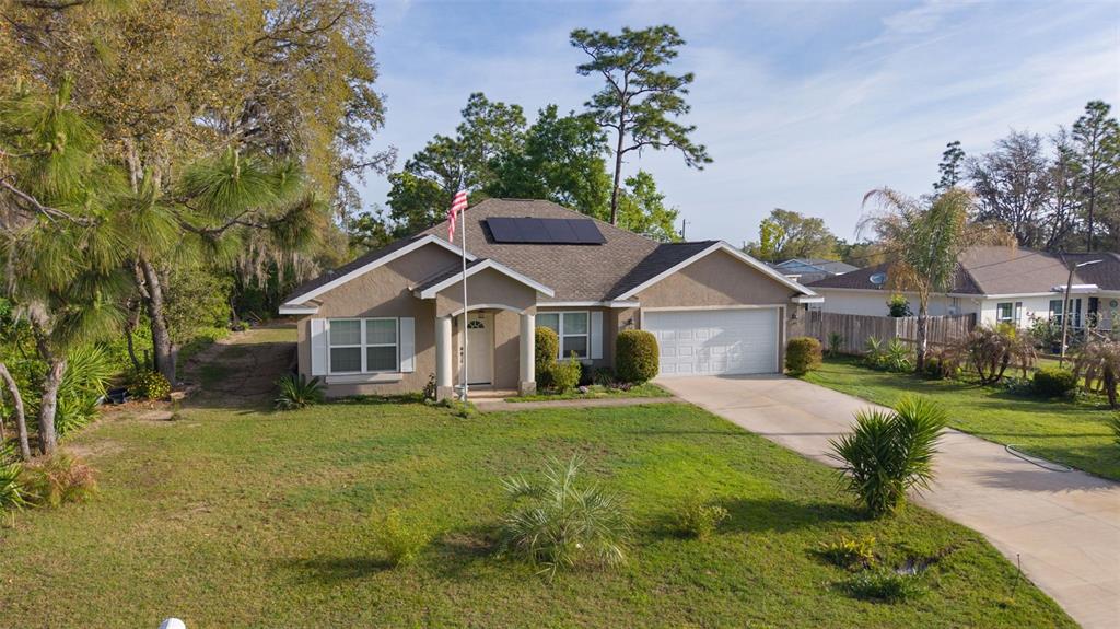 13 Malauka Radial Run Road Ocklawaha, FL 32179 - Photo 1 of 32 a front view of a house with a yard and garage
