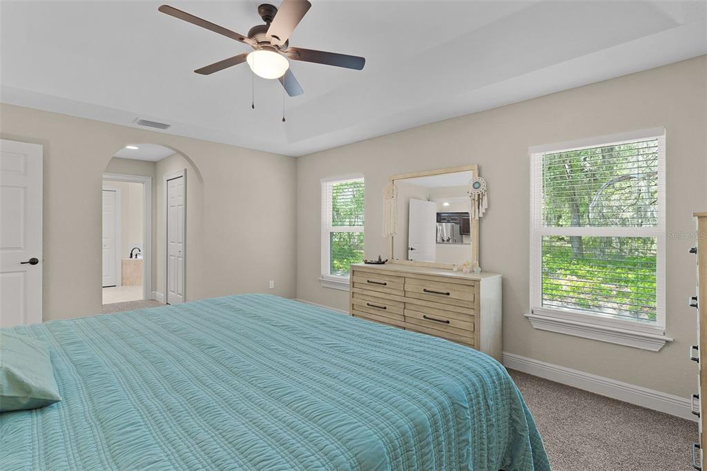 13 Malauka Radial Run Road Ocklawaha, FL 32179 - Photo 13 of 32 a bedroom with a bed and a chandelier