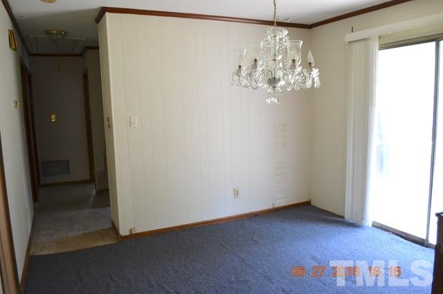 4621 Redwood Road Durham, NC 27704 - Photo 7 of 13 a view of a chandelier in big room with wooden floor
