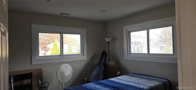 a view of bedroom with wooden floor and window