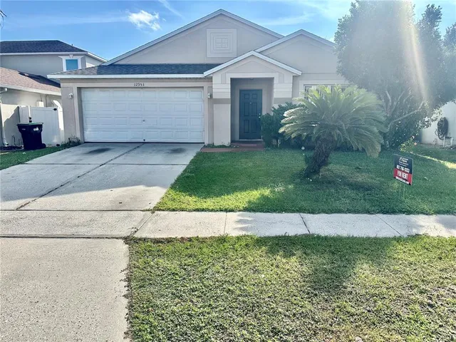 a view of a house with a yard and garage
