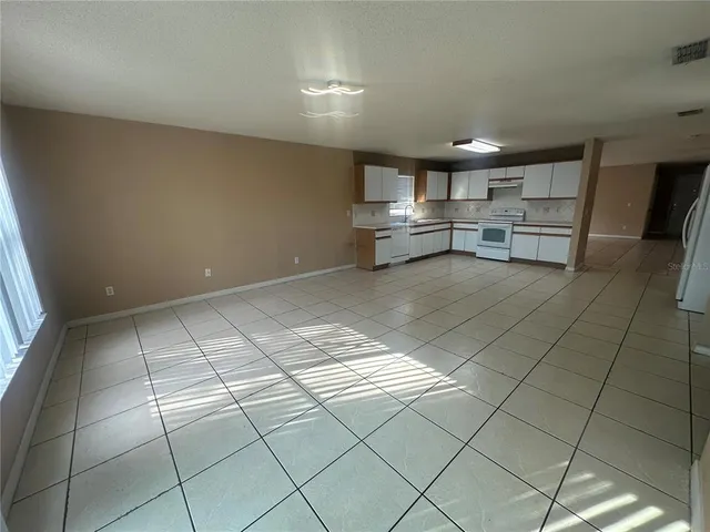 a view of kitchen with cabinets and window