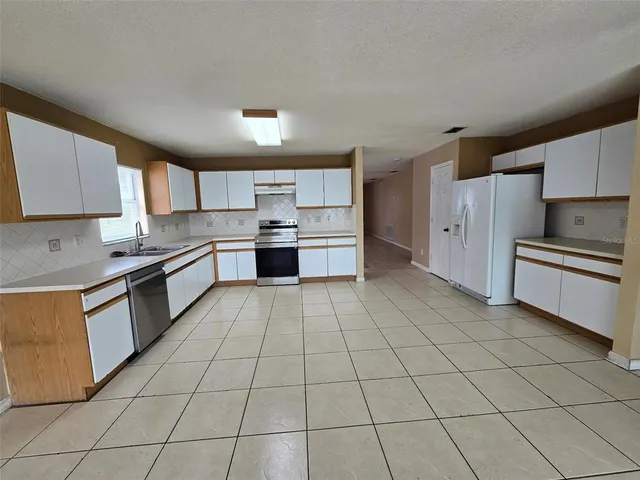 a kitchen with stainless steel appliances granite countertop a stove a sink and a refrigerator