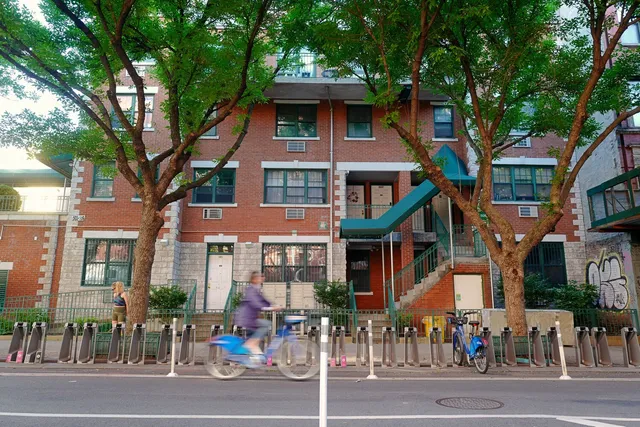 a backyard of a house with table and chairs under an umbrella