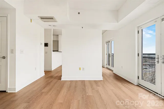 an empty room with wooden floor and cabinet