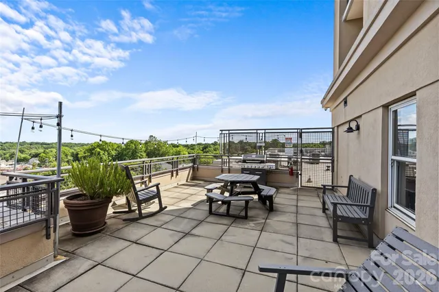 a view of a house with potted plants and a fountain