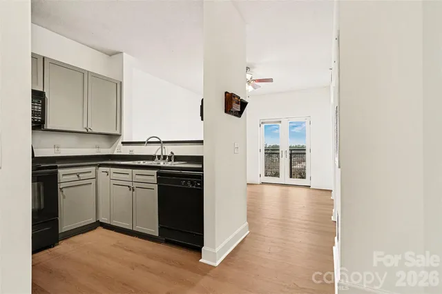 a view of hallway with walk in closet and wooden floor