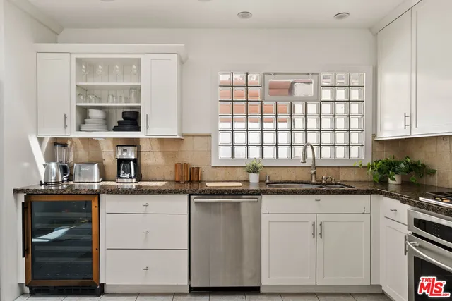 a kitchen with granite countertop white cabinets and white appliances
