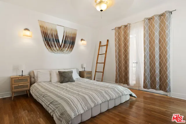 a bedroom with a bed and a painting on the wall