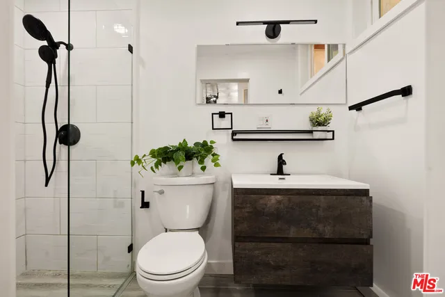a view of bathroom with a toilet a sink and wooden floor