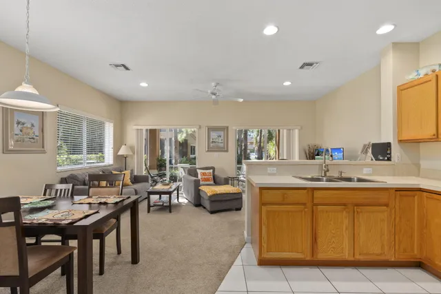 a backyard of a house with table and chairs and potted plants