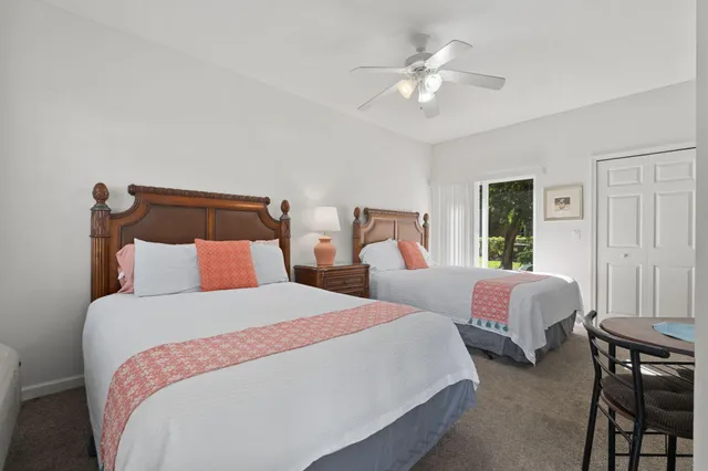 a bedroom with furniture a flat screen tv and a refrigerator