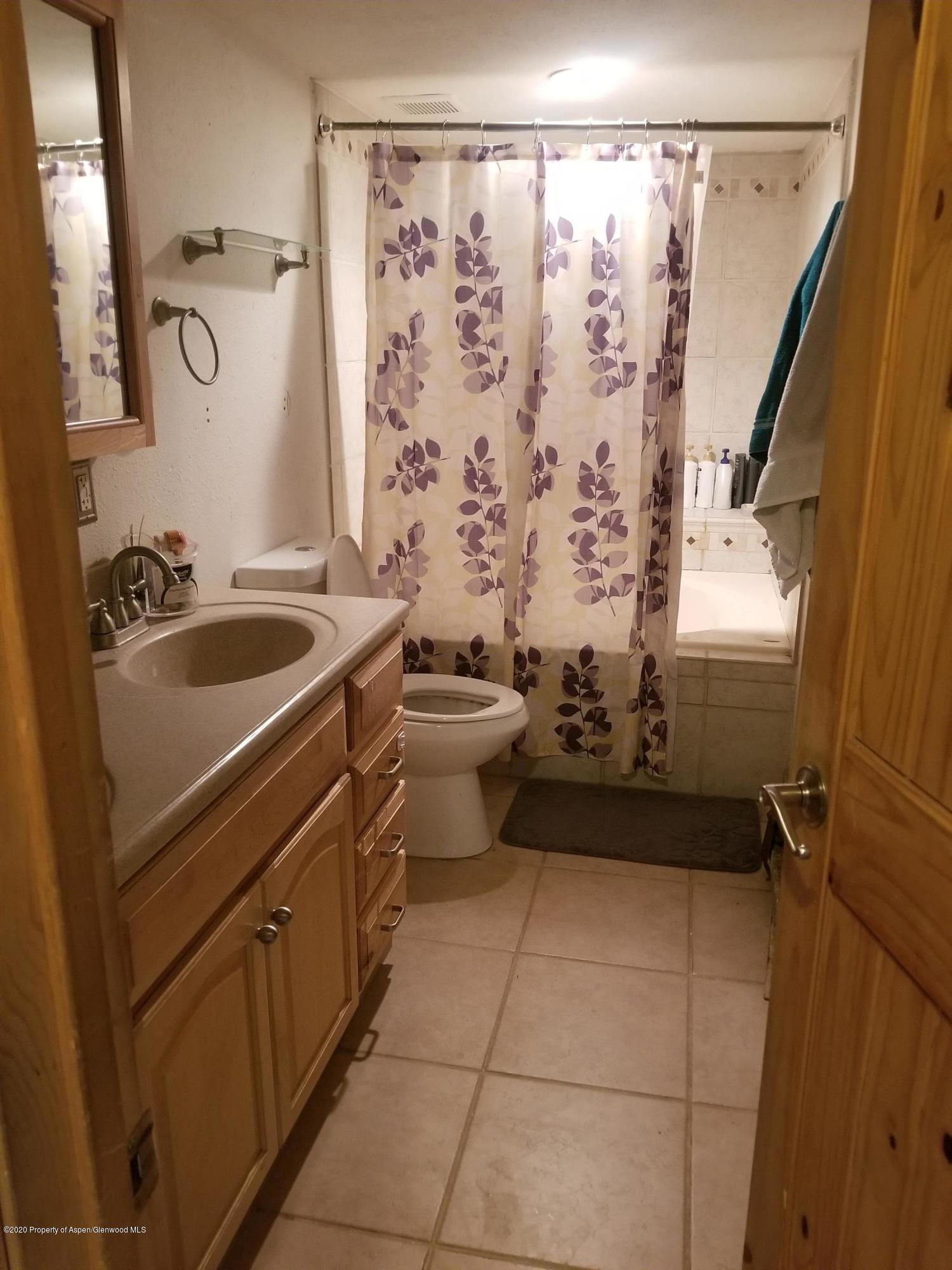 783 Cedar Court Rifle, CO 81650 - Photo 14 of 17 a bathroom with a sink a toilet and shower curtain