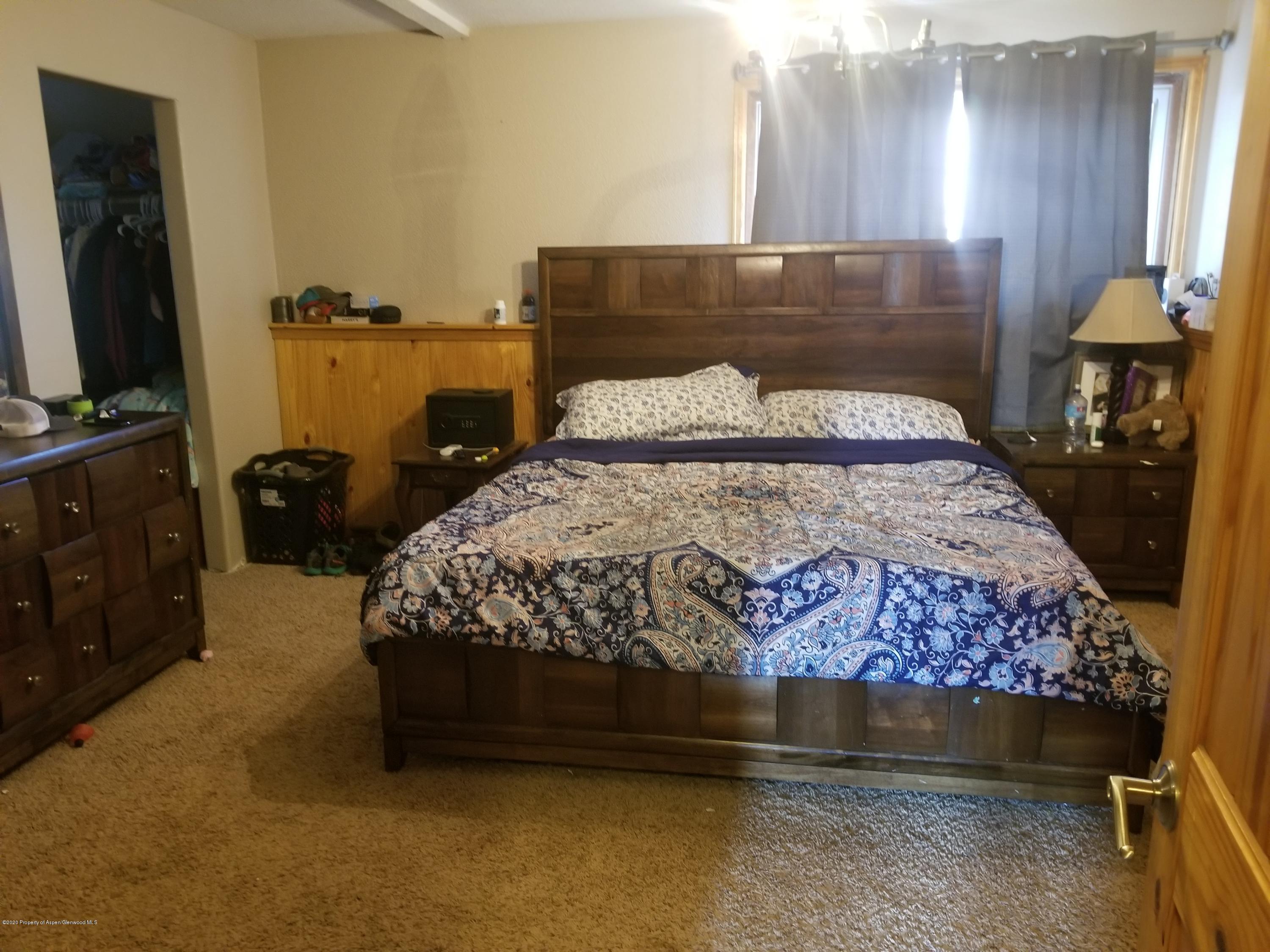 783 Cedar Court Rifle, CO 81650 - Photo 10 of 17 a bedroom with a bed and wooden floor