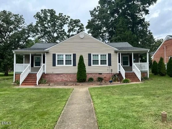 a view of a house with a yard and chairs