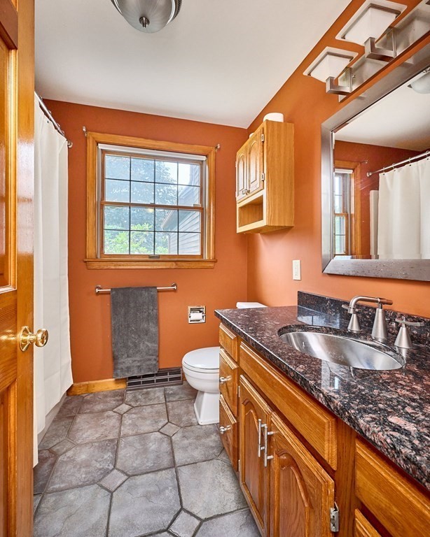 410 Hadley Road Sunderland, MA 01375 - Photo 10 of 32 a bathroom with a granite countertop sink a toilet and a mirror