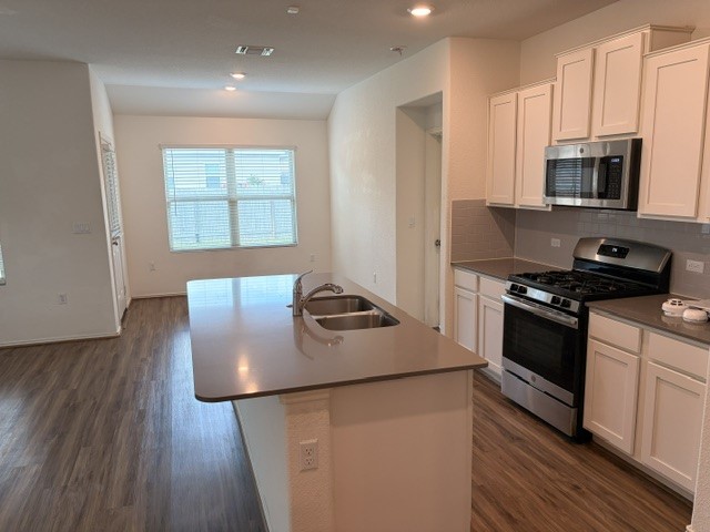 6917 Colorado Bluffs Road Austin, TX 78744 - Photo 3 of 19 a kitchen with stainless steel appliances granite countertop a stove a sink and a microwave