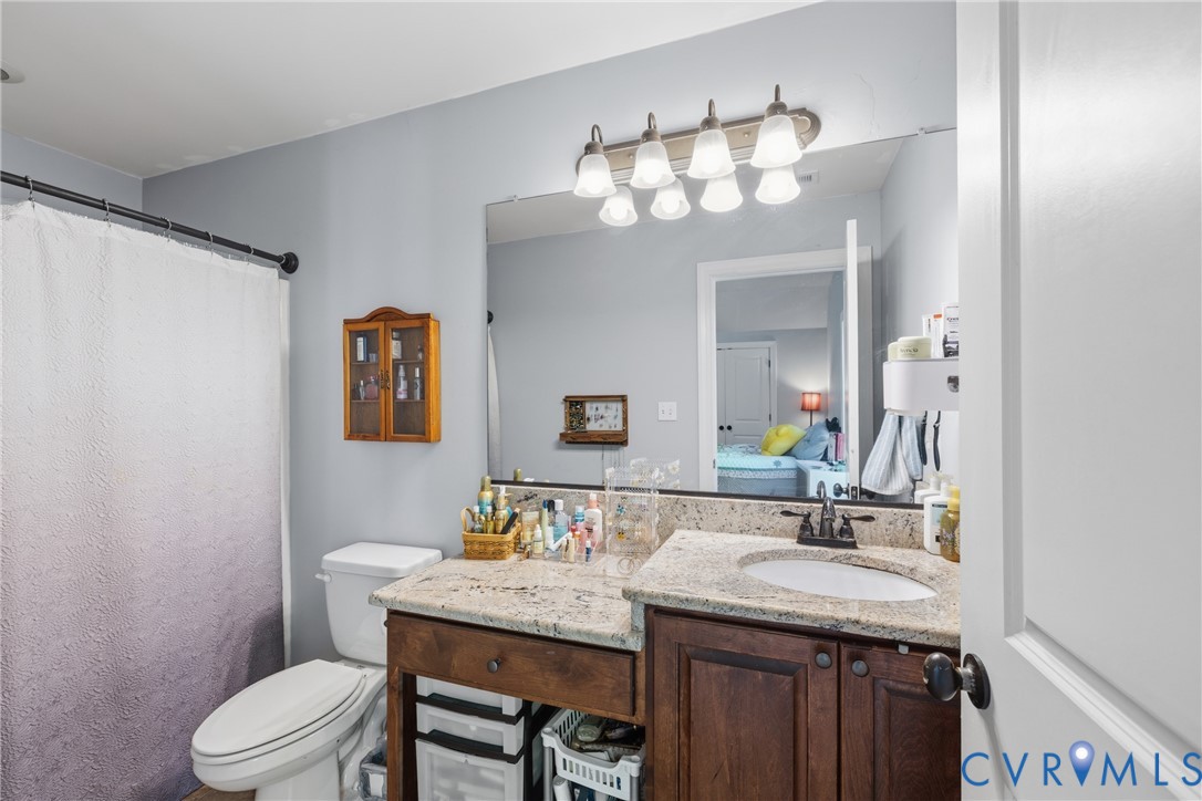 8825 First Branch Lane Chesterfield, VA 23838 - Photo 22 of 49 a bathroom with a granite countertop sink a toilet and a mirror
