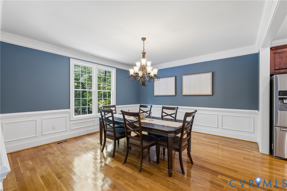 8825 First Branch Lane Chesterfield, VA 23838 - Photo 3 of 49 a dining room with furniture a chandelier and wooden floor