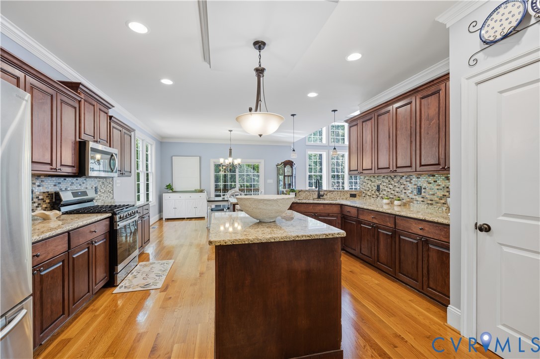 8825 First Branch Lane Chesterfield, VA 23838 - Photo 5 of 49 a kitchen with kitchen island granite countertop a stove top oven a sink dishwasher and wooden cabinets with wooden floor