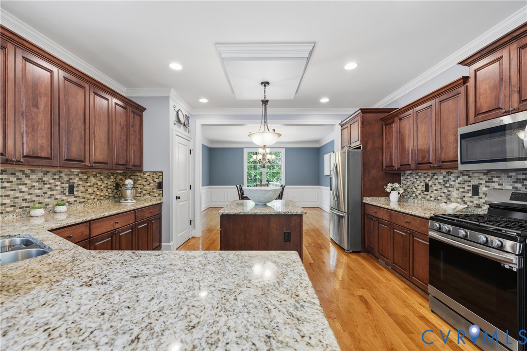 8825 First Branch Lane Chesterfield, VA 23838 - Photo 6 of 49 a large kitchen with stainless steel appliances granite countertop a stove refrigerator a sink dishwasher and wooden cabinets with wooden floor