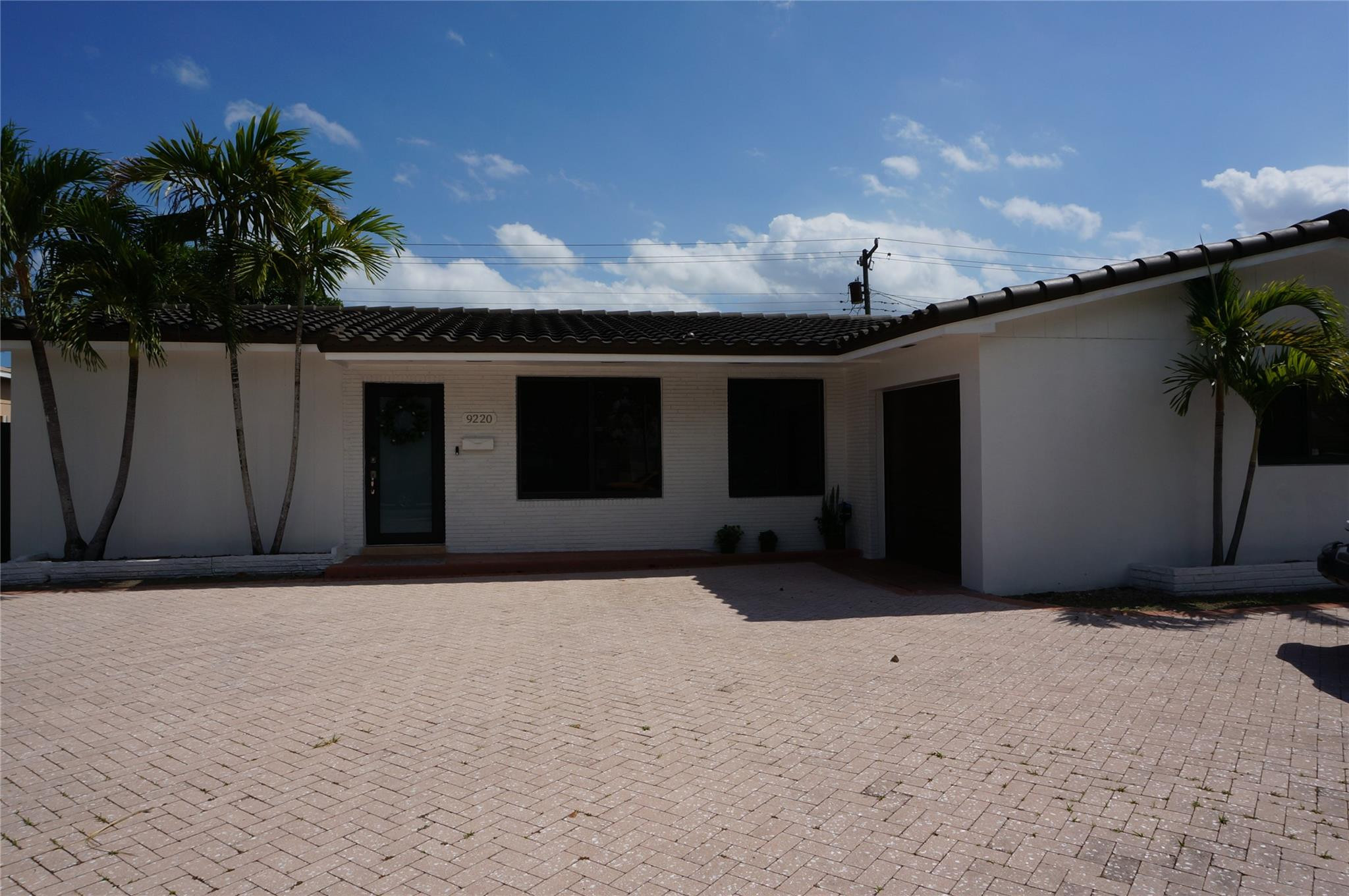 9220 Southwest 56th Street Miami, FL 33165 - Photo 2 of 23 a front view of a house with a yard and garage